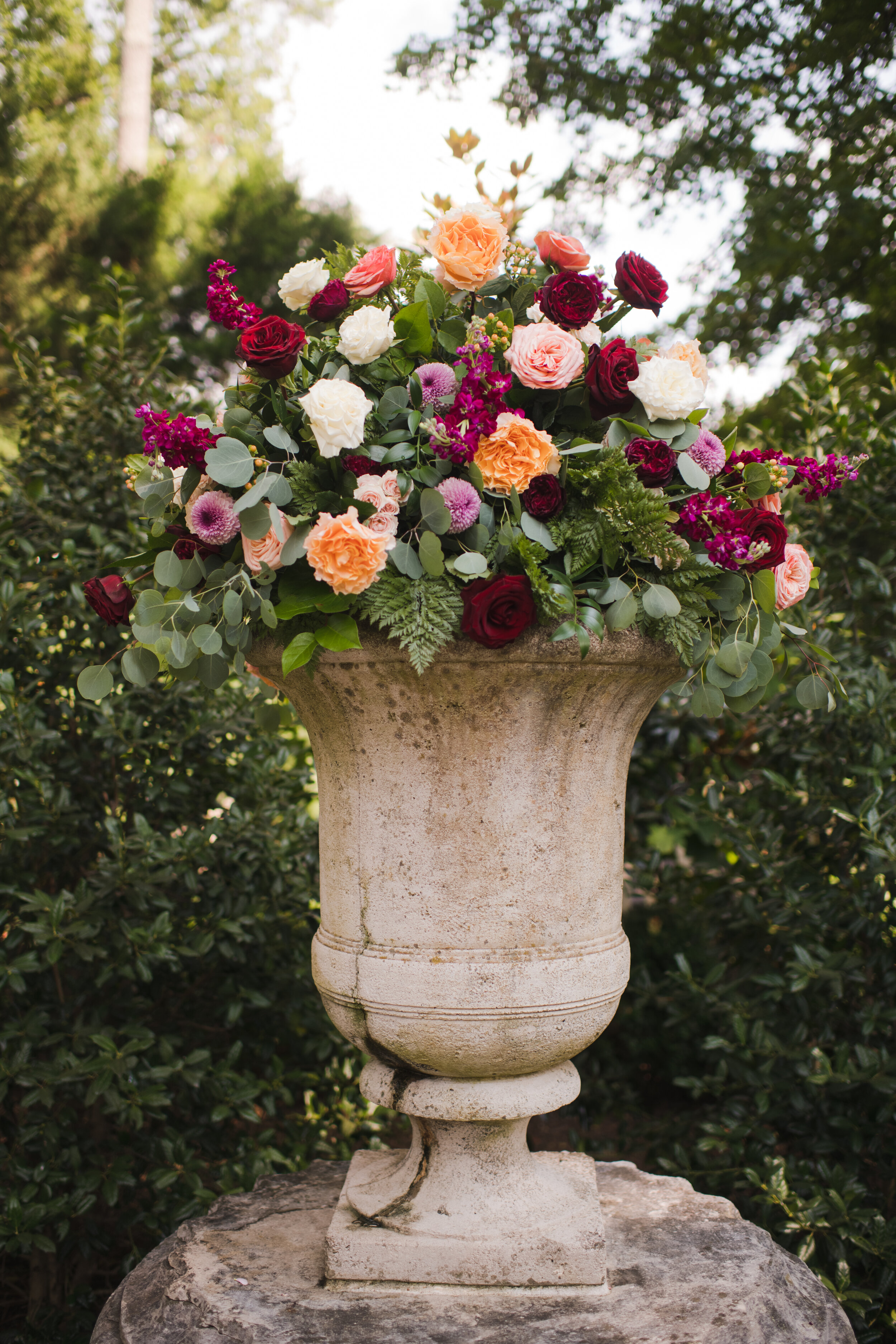 Classic urn arrangement in burgundy, peach, and blush
