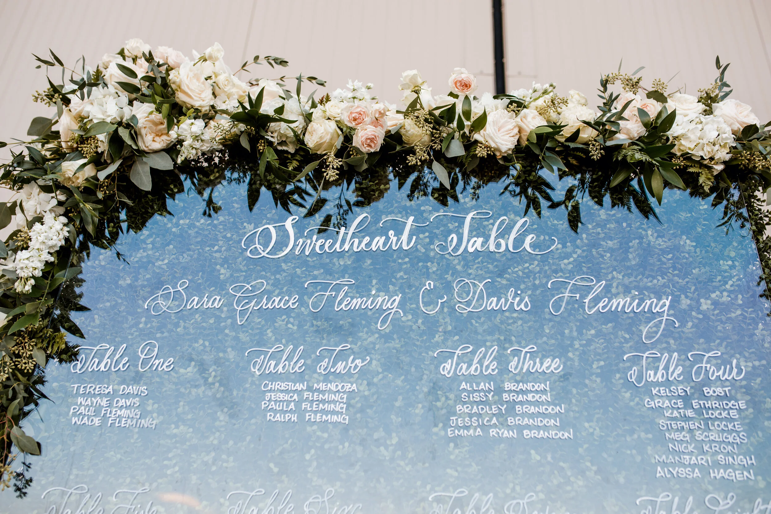 Floral arch framing a sweetheart-table seating display