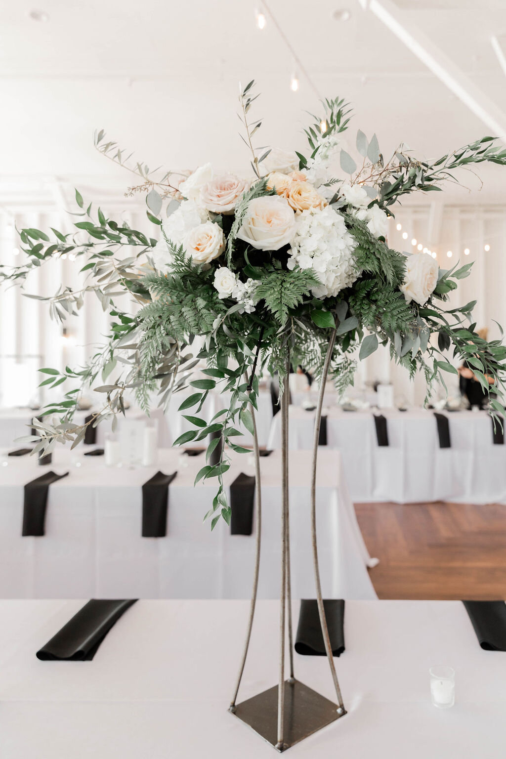 Modern tall centerpiece in white and greenery