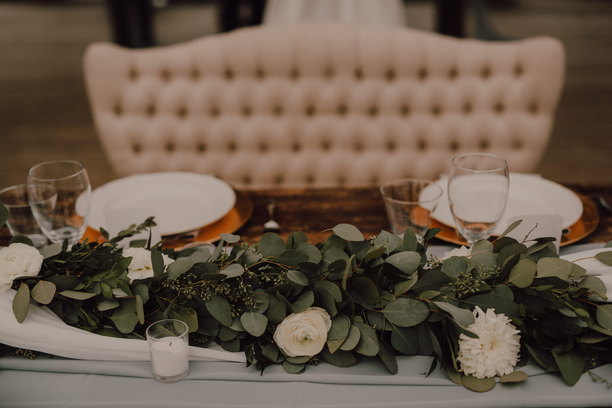 Eucalyptus and blush runner across a reception table
