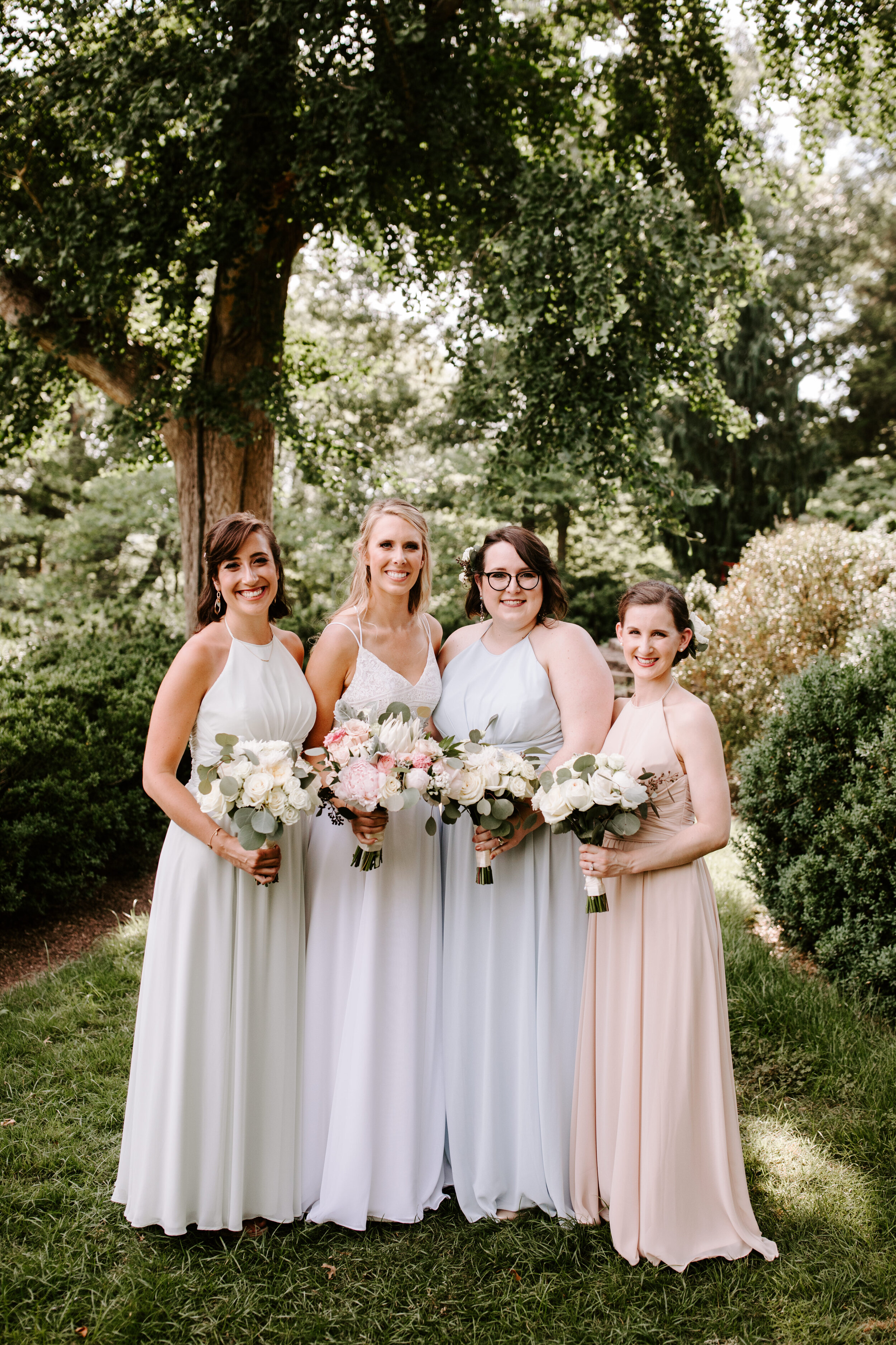 Bridesmaids holding blush and white bouquets